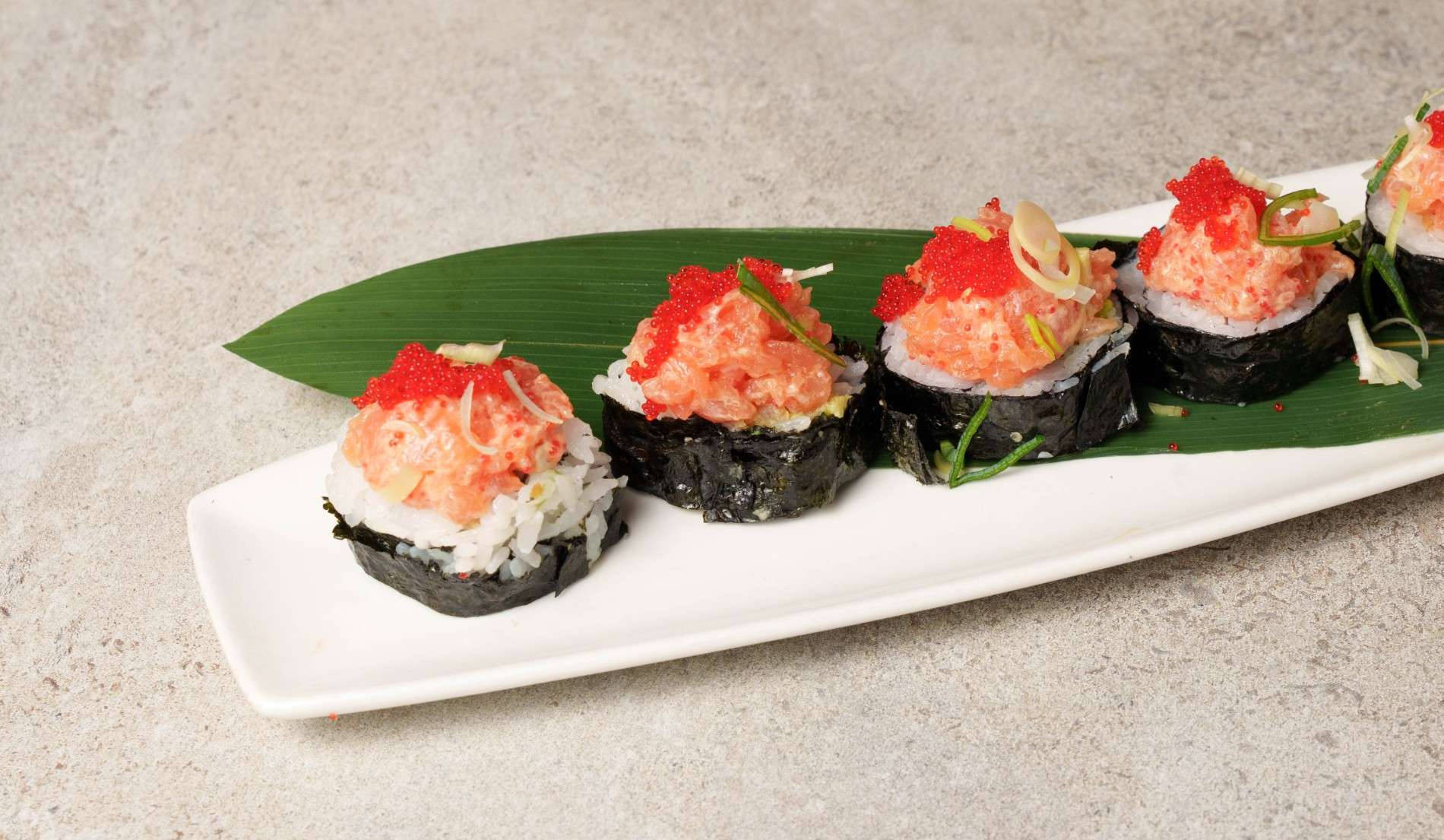 Sushi plated on a white plate against a white background